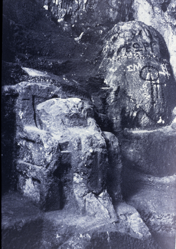 closeup of seated statue with head struck off