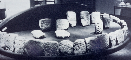 Circle of stones incised with patterns of branches, chevrons and other signs